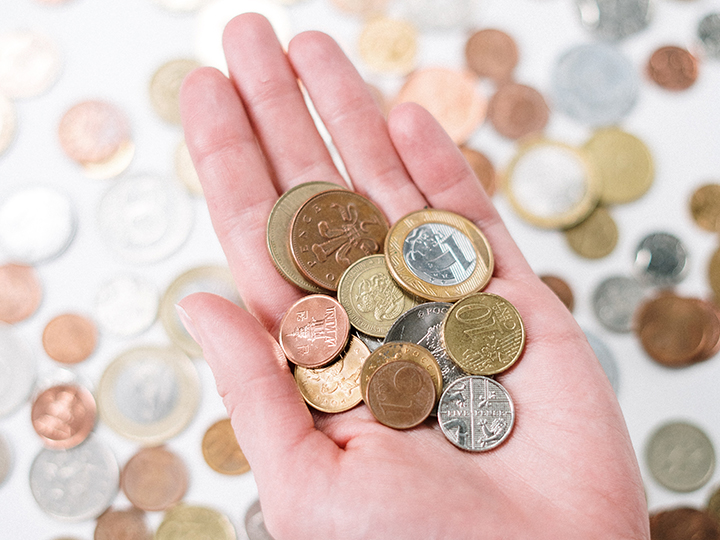 Ein einer Hand sowie im Hintergrund ist Kleingeld zu sehen; DSGVO-Bußgelder sind inzwischen oft kein Kleingeld mehr. Bild: Pexels/cottonbro