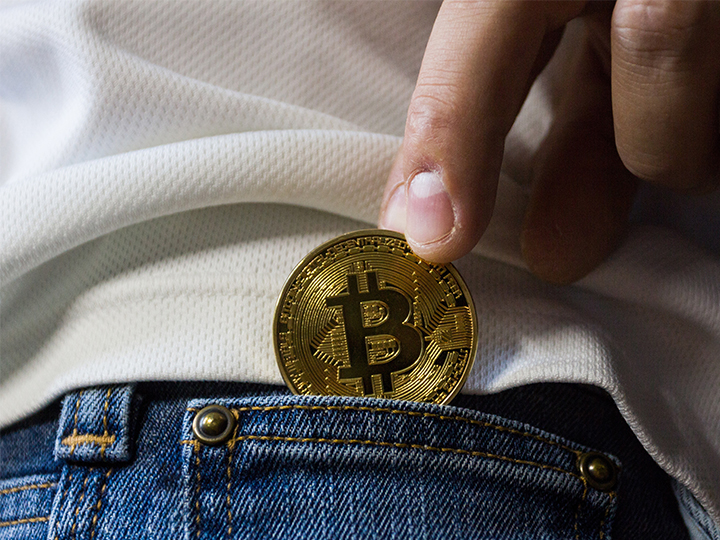 Eine Hand schiebt einen Bitcoin in die Hosentasche. Auch Trickbot ist an Bitcoin-Erpressungen beteiligt. Bild: Pexels/Worldspectrum