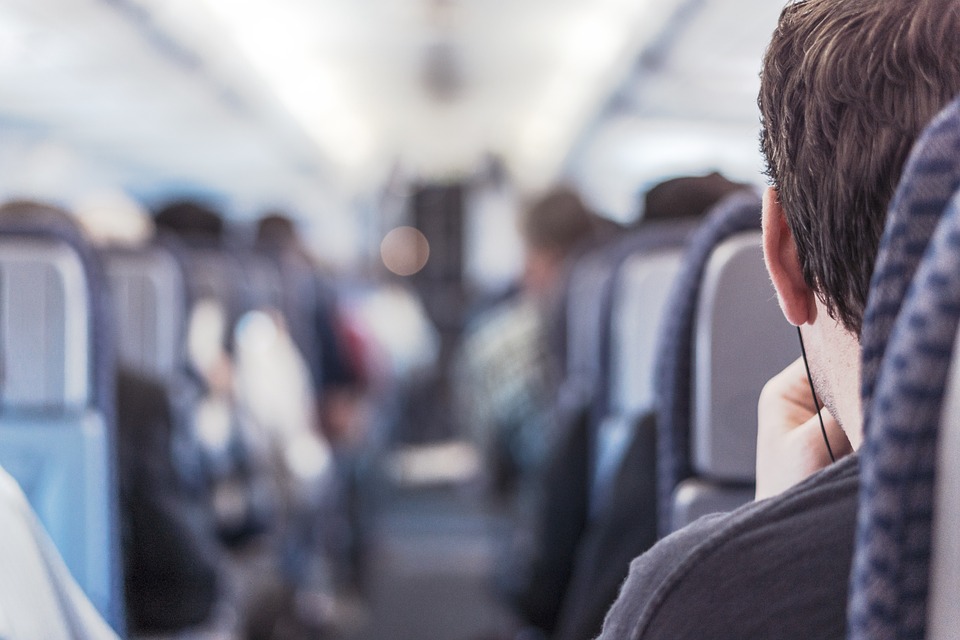Zu sehen ist das Innere eines Flugzeugs. Links und rechts des Mittelgangs sind die Sitze mit Passagieren besetzt. Man sieht sie von hinten. Dank WLAN im Flugzeug können sie unterwegs arbeiten. Bild: www.pixabay.com/RyanMcGuire