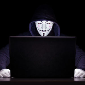 In einer schwarzen Umgebung sitzt eine Person mit schwarzem Kapuzenpulli vor einem Laptop. Nur die Maske und Handschuhe stechen in Weiß hervor. Ob der Hacker in die Honeypot-Falle tritt?, Bild: www.pixabay.com / Michael Treu
