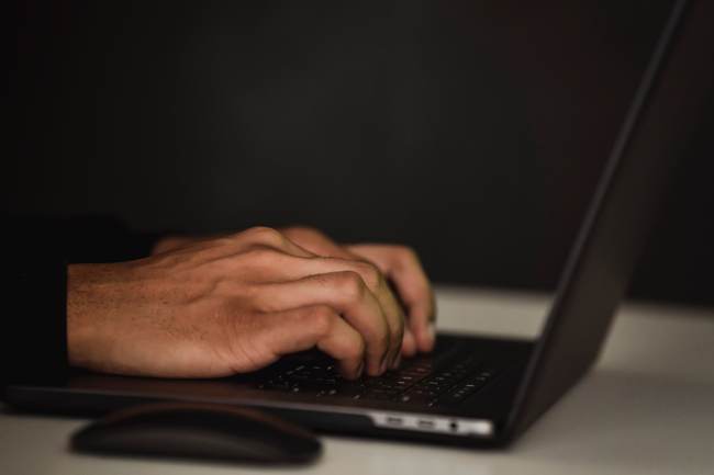 Hände bedienen einen Laptop; vielleicht handelt es sich um einen Hacker. Bild: Pexels/Sora Shimazaki