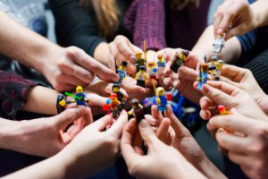 Das Bild zeigt Menschen, die mit Lego-Figuren ein virtuelles Team nachstellen. Bild: Unsplash/Vlad Hilitanu