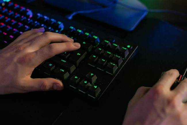Zu sehen sind Hände, die Tastatur und Maus bedienen. Es geht um die Schadsoftware QBot oder auch Qakbot. Bild: Pexels/Alena Darmel