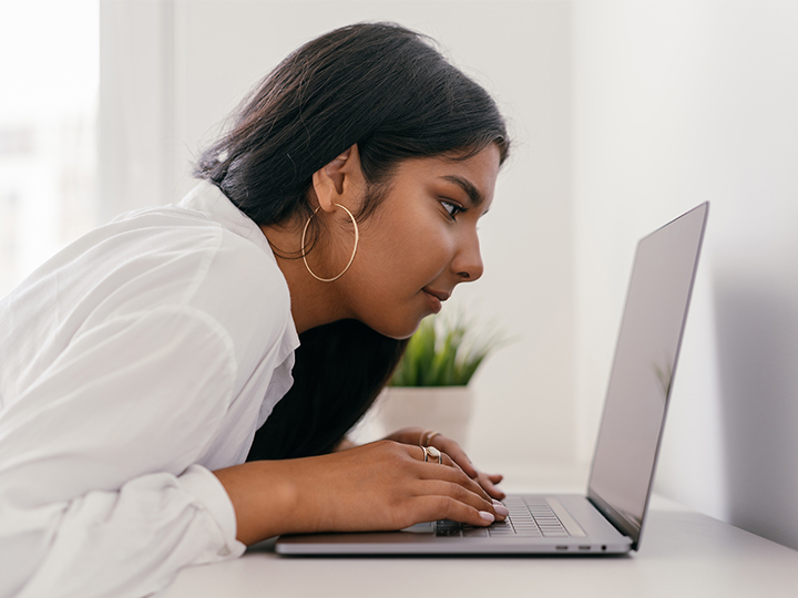 Eine Frau sitzt am Laptop und geht mit dem Gesicht ganz nah an den Bildschirm. Sie versucht Phishing anhand der Phishing-Mail-Beispiele zu erkennen. Bild: Pexels/Mikhail Nilov