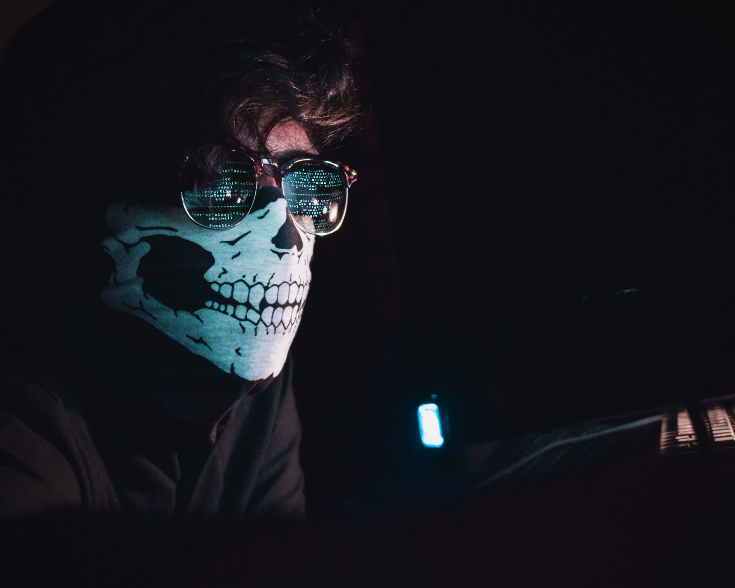 Ein Mann mit Maske sitzt vor einem Bildschirm. Ob er an Cyberangriffe 2020 beteiligt war? Bild: Unsplash/Nahel Abdul Hadi