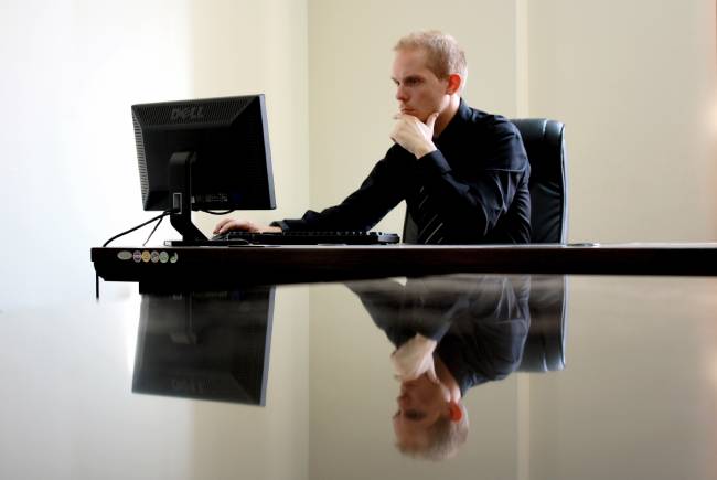 Ein Mann sitzt mit ernstem Gesicht vor seinem Arbeitsrechner. Er hat Bekanntschaft mit Clop gemacht. Bild: Pexels/David McEachan