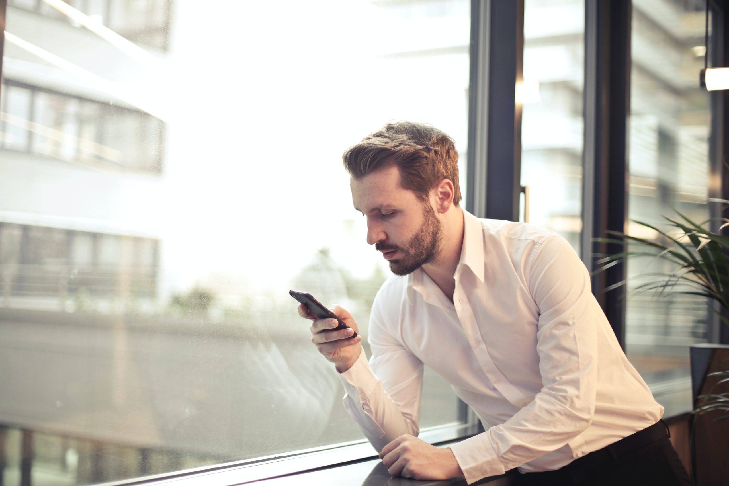 Ein Geschäftsmann sieht auf sein Smartphone. Er nutzt darauf Threema Work. Bild: Pexels / Andrea Piacquadio