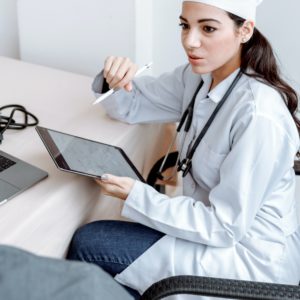 Eine Ärztin ist im Gespräch mit einem Patienten. Auf einem Tablet kann sie die elektronische Patientenakte einsehen. Bild: Pexels/Thirdman