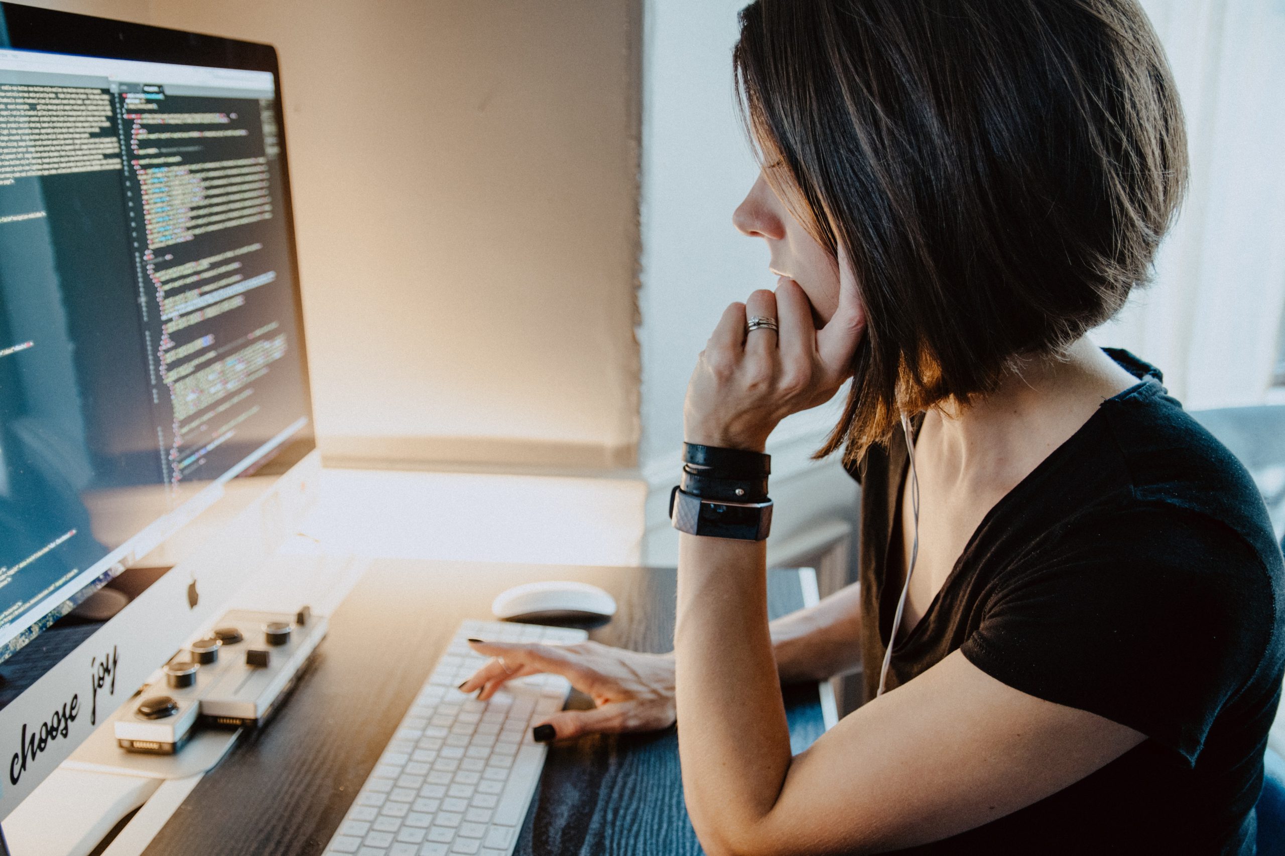 Eine Frau arbeitet an ihrem Rechner und nutzt dabei Programmiersprache. Low-Code-Entwicklung soll ihre Arbeit leichter machen. Bild: Unsplash/Kelly Sikkema