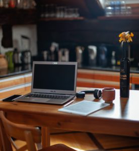 Zu sehen ist eine Küche. am Küchentisch hat jemand wegen der Pflicht zum Home Office seinen provisorischen Arbeitsplatz eingerichtet. Bild: Unsplash/Ben Mysc