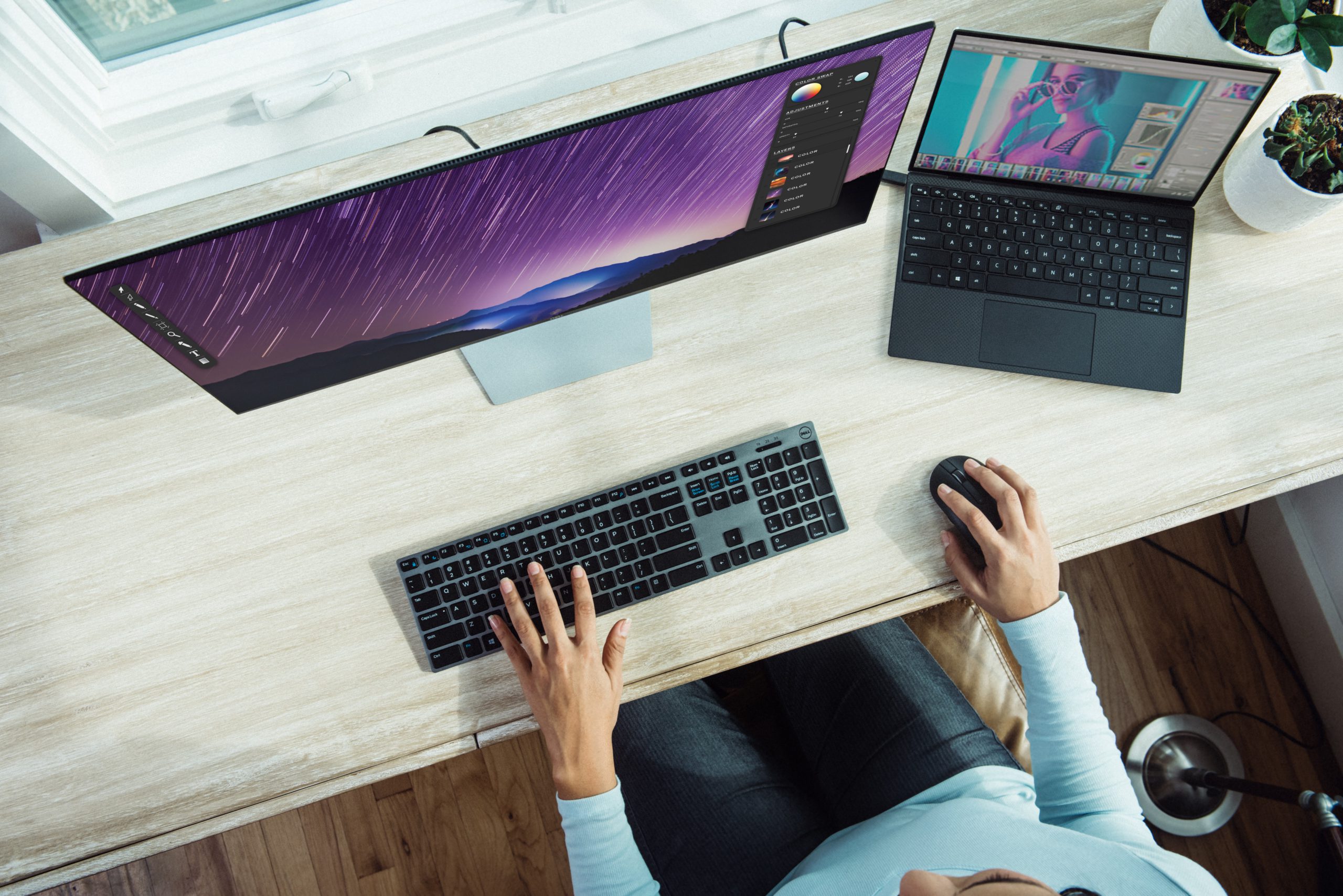 Zu sehen ist aus der Vogelperspektive ein PC-Arbeitsplatz mit Laptop, Monitor, Tastatur und Maus, an dem eine Frau arbeitet. Der Laptop kann Ziel eines Firmware-Angriffs werden. Bild: Unsplash/XPS