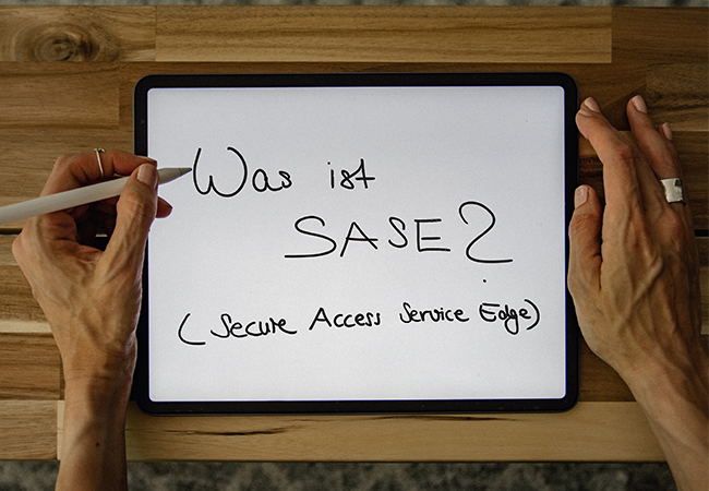 Zwischen zwei Händen liegt ein Tablet, mit einem Stift wurde darauf geschrieben: Was ist SASE? Bild: Unsplash/Kelly Sikkema/IT-SERVICE.NETWORK