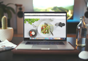 Ein MacBook steht auf einem Küchentisch, darauf ist der Safari-Browser aufgerufen. Bild: Unsplash/Igor Miske