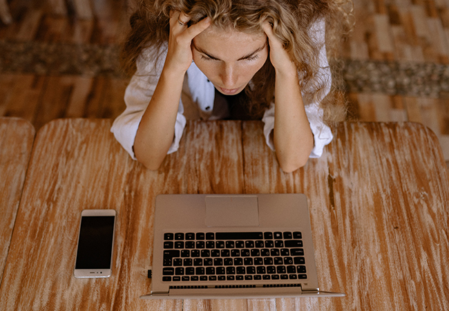 Eine Frau sitzt verzweifelt an ihrem Laptop. Ihr Unternehmen ist Opfer von Ransomware-as-a-Service. Bild: Pexels/Yan Krukov