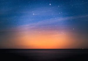 Zu sehen ist ein Abendhimmel; wie Perlen auf einer Schnur reihen sich Satelliten aneinander. Was bedeutet Starlink für Unternehmen? Bild: Unsplash/Marek Piwnicki