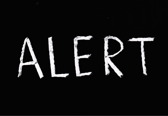 Zu sehen ist eine schwarze Tafel mit dem Kreide-Schriftzug „Alert“. Bei der Anomalie-Erkennung geht es um die rechtzeitige Alarmierung. Bild: Pexels/Anna Tarazevich