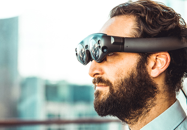 Ein Mann trägt eine futuristische Virtual-Reality-Brille. Darüber soll auch das Internet der Sinne Realität werden. Bild: Unsplash/My name is Yanick