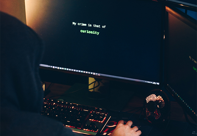Eine Person mit Hoodie sitzt vor einem Computer. Es geht um einen möglichen Missbrauch der Pegasus-Software. Bild: Pexels/Anete Lusina