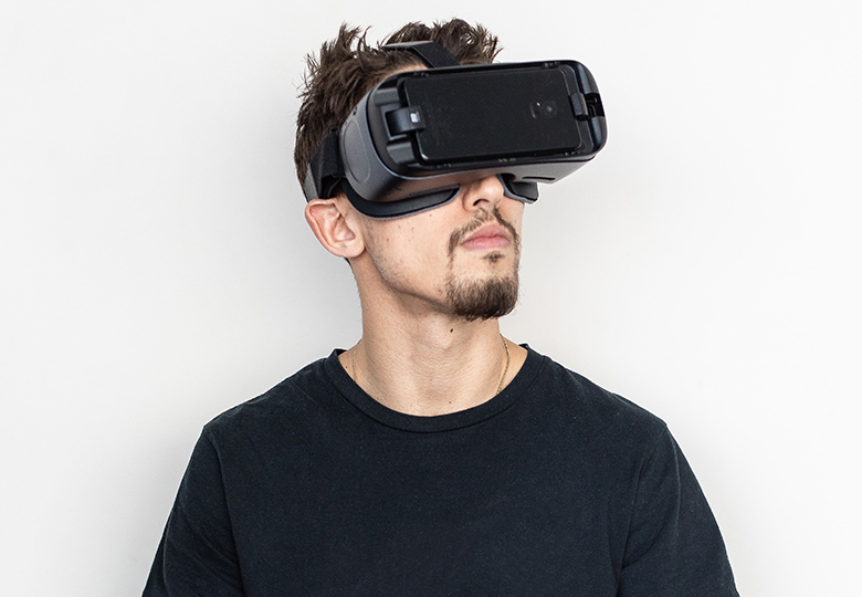 Zu sehen ist ein Mann mit Virtual-Reality-Brille; damit könnte er auch das Metaversum nutzen. Bild: Unsplash/Adrian Deweerdt