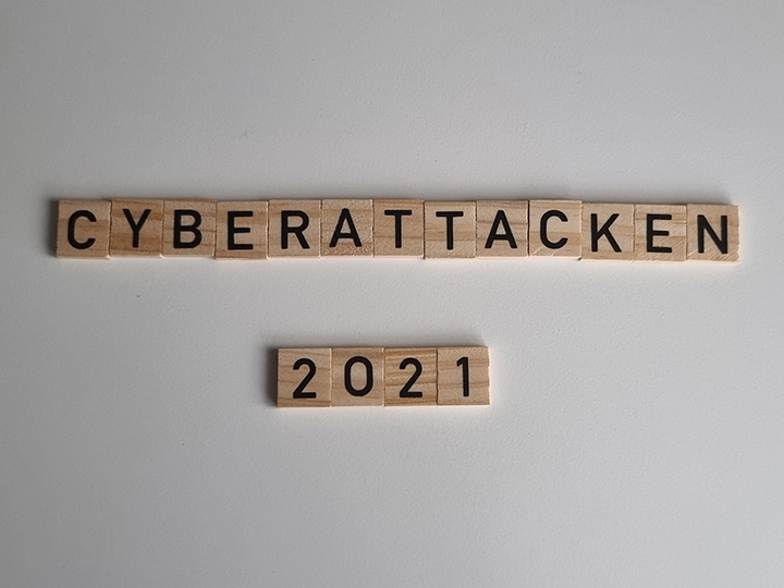 Zu sehen sind Holztafeln mit Buchstaben, die den Schriftzug ergeben: Cyberattacken 2021. Bild: IT-SERVICE.NETWORK