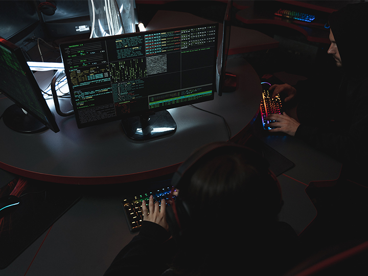 Zu sehen sind zwei Hacker an ihren Rechnern an einem Gruppentisch. Ob sie für Cyberattacken 2021 verantwortlich sind? Bild: Pexels/Tima Miroshnichenko