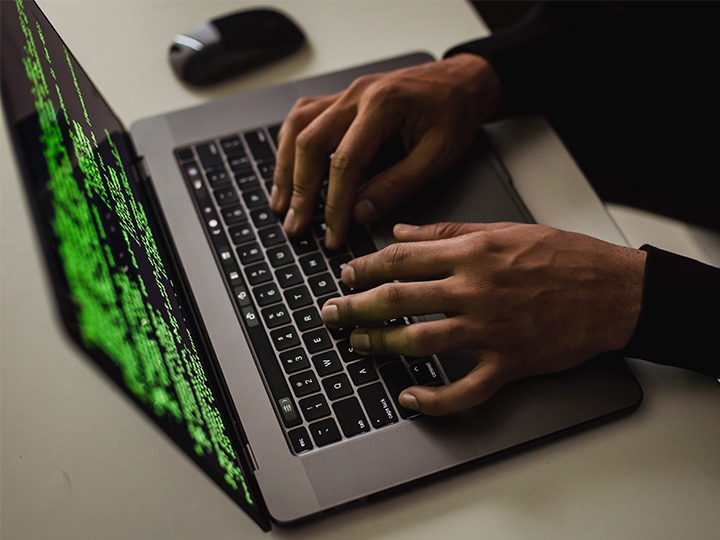 Hände bedienen einen Laptop mit Programmiercode. Der Verfassungsschutz warnt vor Angriffen der Gruppe APT27. Bild: Pexels/Sora Shimazaki