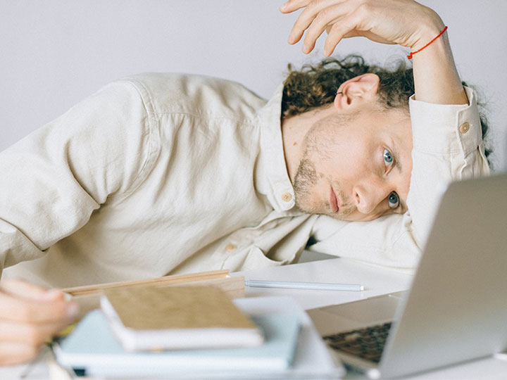 ausgebrannter Mann vor seinem Laptop. Burnout durch Corona. Bild: Pexels/Nataliya Vaitkevich