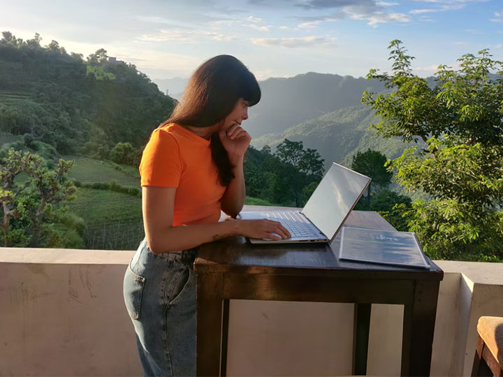 Zu sehen ist eine Frau, die an ihrem Laptop auf der Terrasse arbeitet. Thema des Artikel ist die Tatsache, dass gebrauchte Hardware nicht immer so nachhaltig ist, wie es auf den ersten Blick scheint. Bild: Unsplash/ Dessidre Fleming