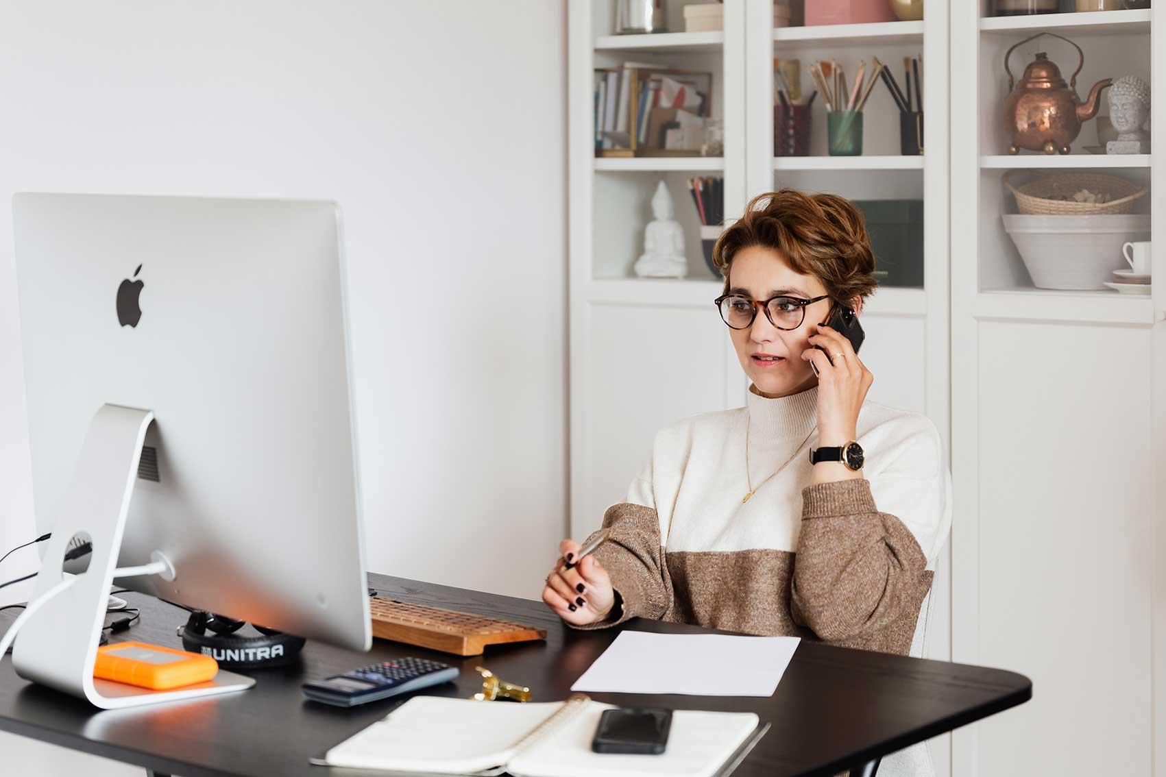 zu sehen ist eine Frau am Schreibtisch vor ihrem PC, die telefoniert. Das Thema ist der Pretext als Instrument für Social Engineering Angriffe. Bild: Pexels/Karolina Grabowska