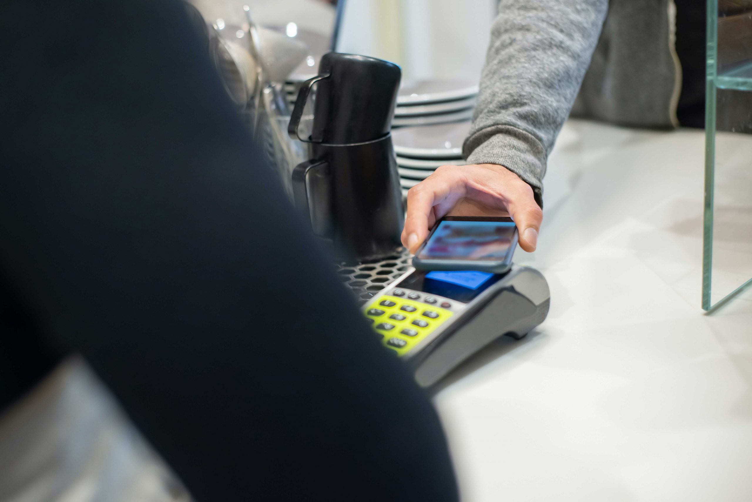 zu sehen sit eine Person, die in einem Geschäft mit ihrem Smartphone bezahlt. Bild: Pexels/Kampus Production