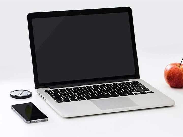 zu sehen ist ein ausgeschaltetes Macbook auf einem Schreibtisch. Bild: Pexels/Karsten Madsen