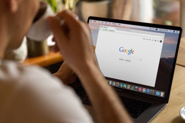 Eine Frau sitzt am Laptop, trinkt einen Schluck Kaffee und ruft dabei Google Bard auf. Bild: Pexels/Firmbee.com