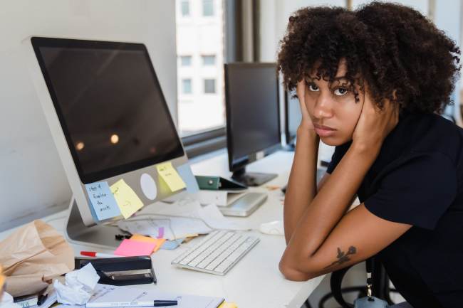 Eine Frau sitzt genervt am PC; sie kann wegen eines IT-Ausfalls nicht arbeiten. IT-Monitoring schützt vor solchen Problemen. Bild: Pexels/Mizuno K