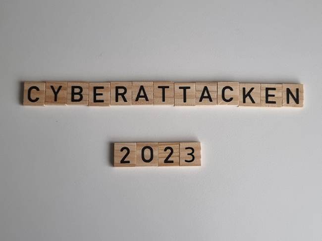 Zu sehen ist der Schriftzug Cyberattacken 2023 aus Scrabble-Holzbuchstaben. Es geht um die Cyberangriffe 2023. Bild: IT-SERVICE.NETWORK