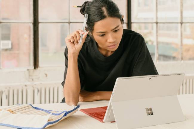 Zu sehen ist eine Frau an einem Microsoft-Gerät, die vielleicht Office 2016 nutzt und sich fragt: Wie lange kann man Office 2016 noch nutzen? Bild: Unsplash/M. Cooper