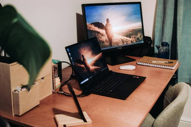 Zu sehen ist ein Laptop mit externem Monitor mit Windows-Betriebssystem. Bild: Unsplash/Nighthawk Shoots