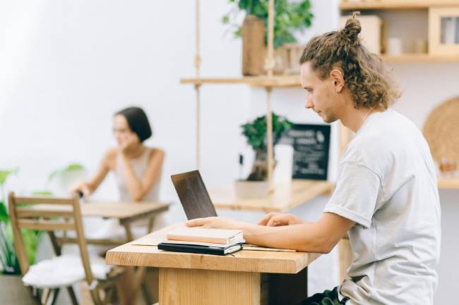 Zu sehen sind zwei Personen, die in einem Büro am Laptop arbeiten. Ihr Verhalten bei Phishing-Versuchen fließt in den Phish-prone Percentage ein. Bild: Unsplash/Nataliya Vaitkevich