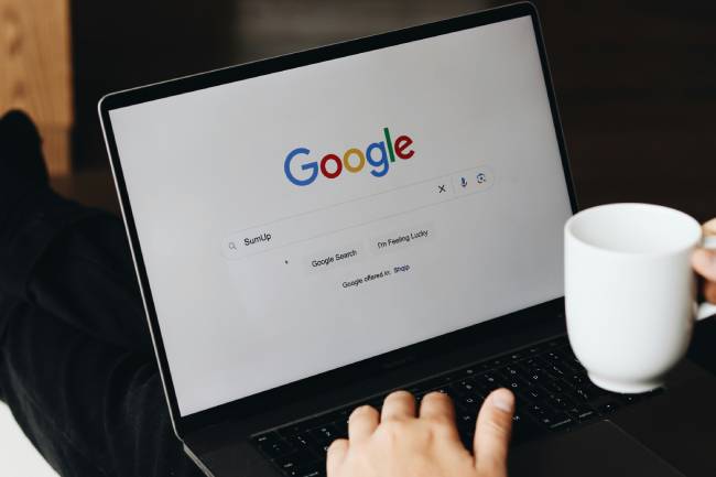 Zu sehen ist ein Laptop, auf dem Google aufgerufen ist. Es geht um ClickFix-Attacken, bei denen Angreifer legitime Webseiten fälschen. Bild: Unsplash/SumUp