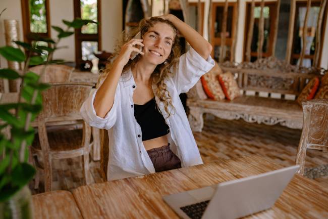 Zu sehen ist eine Frau Zuhaus vor Laptop und am Telefonieren für die mentale Stärke im Home Office wichtig ist. Bild: Pexels/Yan Krukau