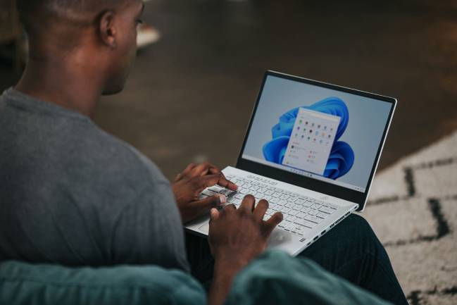 Zu sehen ist ein Mann der an einem Microsoft Laptop arbeitet und vermutlich aktuell Updates im Windows Server 2025 herunterlädt. Bild: Unsplash/Windows