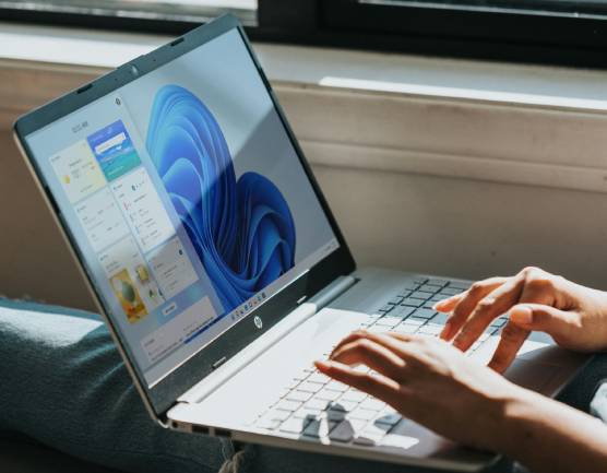 Zu sehen ist eine Person die an einem Microsoft Laptop arbeitet und vermutlich gerade die Updates vom Windows Server 2025 installiert. Bild: Unsplash/Windows
