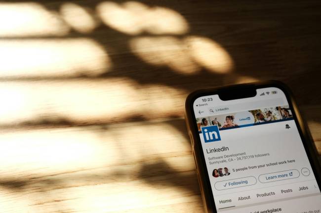 Zu sehen ist ein Handy mit einem LinkedIn Profil auf dem womöglich ein Fakr Profil von Führungskräften zu sehen ist. Bild: Pexels/Airam Dato-on