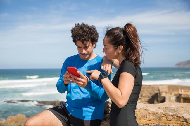Zu sehen ist ein Paar welches im Urlaub das handy nutzt und vielleicht in eine cyberfalle tappt sie sollten eher digital detox verfolgen. Bild: Pexels/Kampus Production