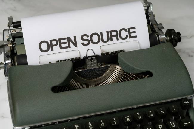 Zu sehen ist eine alte Schreibmaschine mit dem Wort Open Source was als Symbolbild dienen soll. Bild: Pexels/Markus Winkler