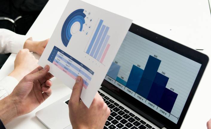 Zu sehen ist eine Person vor einem Laptop mit Diagrammen die wahrscheinlich gerade an Maßnahmen für das Reputationsmanagement arbeitet. Bild: Pexels/Artem Podrez