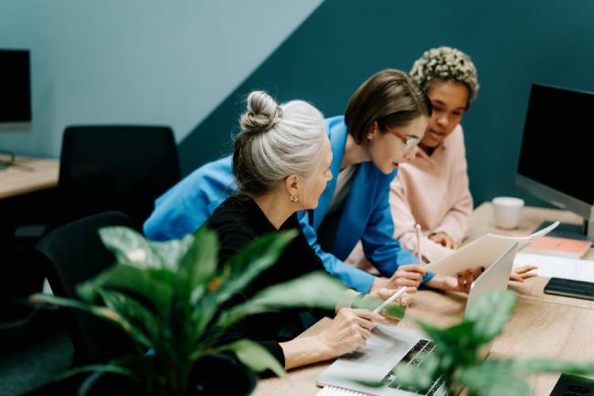 Zu sehen sind drei Mitarbeiter vor einem Laptop die womöglich gerade an einer Strategie für das Reputationsmanagement arbeiten. Bild: Pexels/cottonbro studio