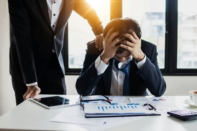 Zu sehen ist ein verzweifelter Mitarbeiter vor Unternehmszahlen die wahrscheinlich aufgrund von narrativen Angriffe negativ geworden sind. Bild: Pexels/Khwanchai Phanthong