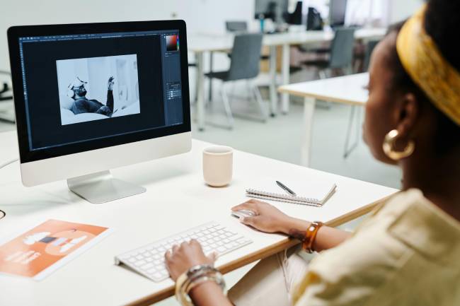 Mit KI werden Bilder heute automatisch erkannt, verbessert und neu gestaltet das symbolisiert hier eine Frau die vor ihrem PC ein Bild bearbeitet. Bild: Pexels/Darlene Alderson