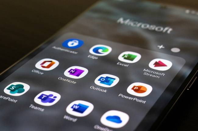 Das Microsoft Support-Ende 2026 betrifft zahlreiche verbreitete Produkte wie Windows, Office, Server- und Entwicklungstools. Das zeigt hier ein Smartphone mit diversen Microsoft Apps. Bild: Unsplash/Ed Hardie